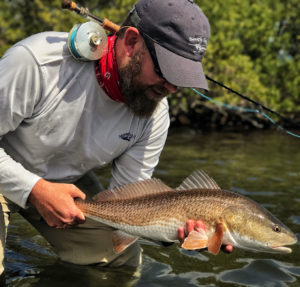 Captain Andrew Mizell Hoding a Redfish and a Fly Rod In Jacksonvill Saltwater Marsh-1090